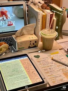 an open laptop computer sitting on top of a desk next to a cup of coffee