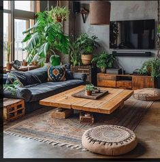 a living room filled with lots of plants next to a couch and coffee table in front of a window