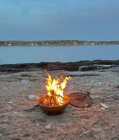 a fire pit sitting on top of a sandy beach