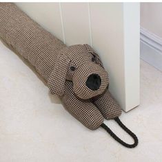 a stuffed dog is tied to the side of a wall