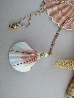 this seashell necklace is a lovely statement piece or pairs well with any of the pieces in our Gadgets and Gizmos collection Shell-shaped Jewelry With Pearl Pendant, Shell-shaped Pearl Pendant Jewelry, White Shell-shaped Jewelry With Pearl Pendant, White Shell-shaped Pearl Pendant Jewelry, White Shell-shaped Necklace For Gift, White Shell-shaped Necklace For A Gift, Mother Of Pearl Shell-shaped Necklace In Pearl White, Elegant White Shell Pendant, Pearl White Mother Of Pearl Shell-shaped Necklace