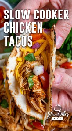 someone holding a chicken taco in their hand with the text slow cooker chicken tacos