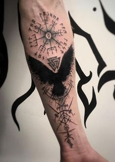 a person with a tattoo on their arm that has an eagle and compass in it