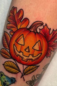 a tattoo with a pumpkin and leaves on it