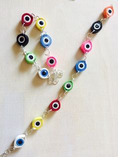 a multicolored evil eye bracelet on a white surface