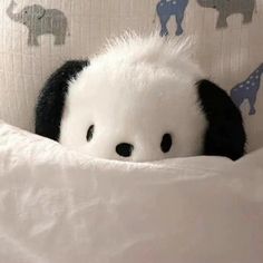 a stuffed animal is peeking out from under the covers