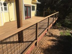 a house with a metal fence around the front door and side porch area on top of it