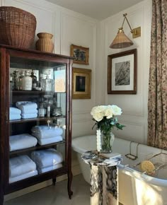 a bath room with a tub and a shelf filled with towels on top of it