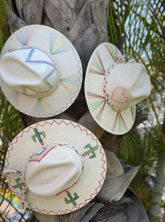 Custom designed and hand made hats by artisans in San Jose Del Cabo, Mexico. These hats are one size fits most with an elastic band inside to add comfort and fit for all head sizes. San Jose Del Cabo Mexico, Rainbow Fan, Girls Crafts, Hat Burning, Spring Hat, Custom Made Hats, Beach Heart, Hat Art, Cabo Mexico