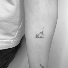 a woman's leg with a small house tattoo on the left side of her arm