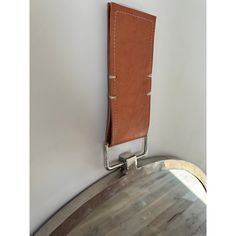 a brown leather case hanging on the side of a wall