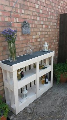 an outdoor bar made out of old pallets and used as a planter for flowers