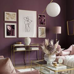 a living room with purple walls and gold accents on the coffee table in front of it