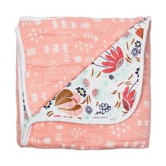 an orange and white blanket with floral print on the front, folded over it's edge