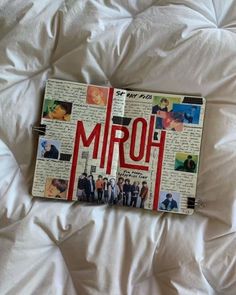 an open notebook with the word mrq on it laying on a bed covered in white sheets