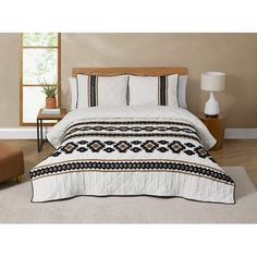 a bed with white and black bedspread in a room