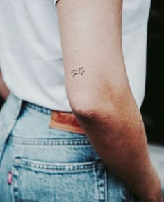 a woman's arm with a small tattoo on the left side of her arm