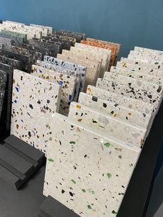 several pieces of white and black marble on display in front of a blue wall,