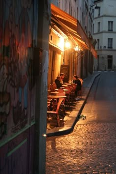 people sitting at tables in an alley way