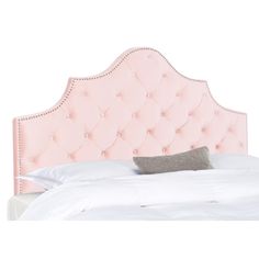 an upholstered pink headboard with buttons on the top and bottom, in front of a white bed