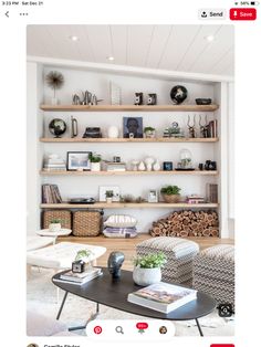 a living room filled with lots of furniture and bookshelves on top of wooden shelves