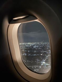 an airplane window looking out at the city lights