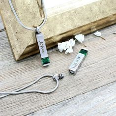 a couple of necklaces sitting on top of a wooden floor next to a window