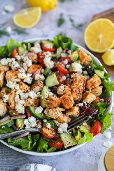 a salad with chicken, cucumber, tomatoes and feta cheese on it