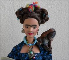 a doll is holding a monkey and wearing a blue dress with multicolored beads