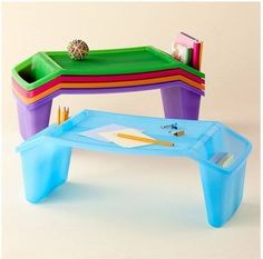 a plastic table with writing utensils and pencils on it in front of a white background