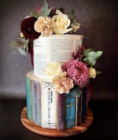 a multi - tiered cake decorated with books and flowers