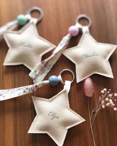 three star keychains with names on them sitting on top of a wooden table