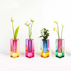 three different colored vases with flowers in them