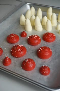 red and white desserts are arranged on a baking sheet