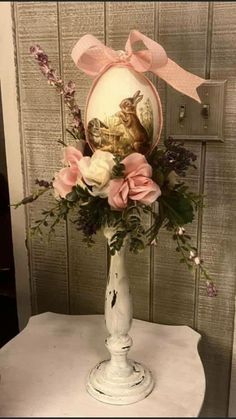 a vase with flowers and an egg on it