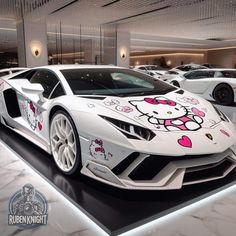 a white car with hello kitty decals on it's side in a showroom