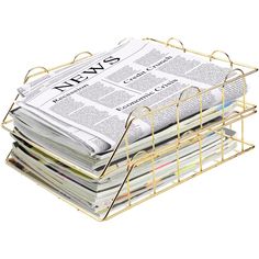 a stack of newspapers sitting on top of a metal basket next to a newspaper holder