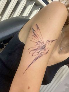 a woman with a hummingbird tattoo on her arm