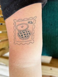 a person with a small tattoo on their arm that has an image of a basket