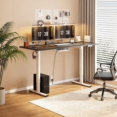 a desk with two clocks on it and a chair in front of the window, next to a potted plant