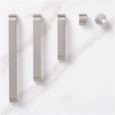 three different types of metal objects on a white surface with marble top and bottom part