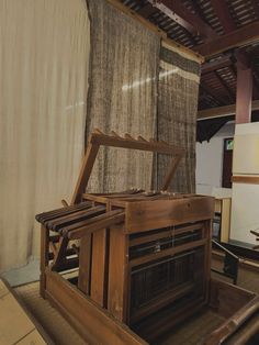 an old fashioned radio sitting on top of a wooden table next to a curtained wall