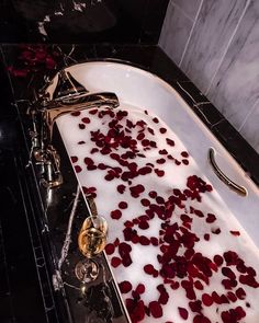 the bathtub is filled with rose petals and water