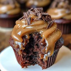 a chocolate cupcake with frosting and sprinkles on a white plate