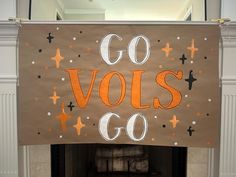 a sign that says go volls go hanging from a fireplace