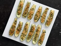 zucchini stuffed with parmesan cheese and herbs on a white platter