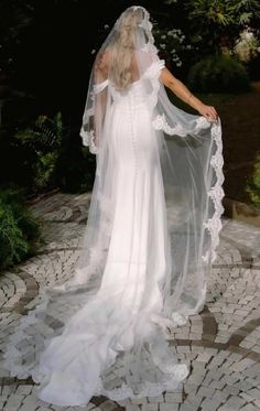 a woman wearing a white wedding dress and veil