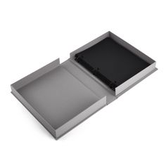 an open box with a black cover on the top and bottom, sitting in front of a white background