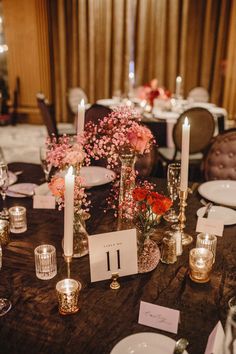 the table is set with candles, flowers and place cards for guests to sit at