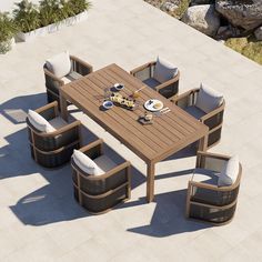 an outdoor dining table with six chairs and two plates on it, next to some rocks